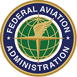 A circular Federal Aviation Administration seal: a gold eagle silhouette superimposed over a green globe with latitude and longitude lines; navy-blue outer ring reads "Federal Aviation Administration" with white stars.