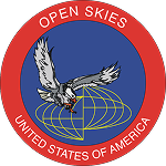 Circular U.S. patch: bald eagle swoops downward clutching red-and-white sensor over a gold wireframe globe on a blue field with red border reading "OPEN SKIES — UNITED STATES OF AMERICA."